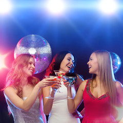 three smiling women with cocktails and disco ball