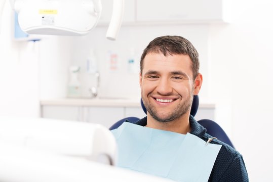 Smiling young man at dentist's surgery