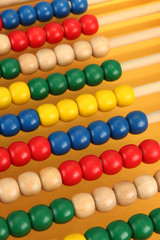 Bright wooden toy abacus, on yellow background