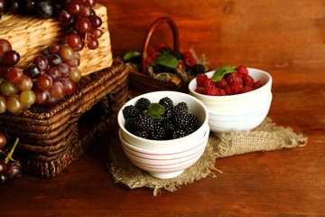 Assortment of juicy fruits and berries on wooden background