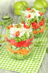 Tasty salad with fresh vegetables on wooden table