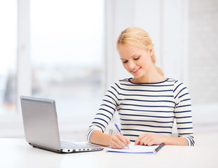 smiling student with laptop computer and documents