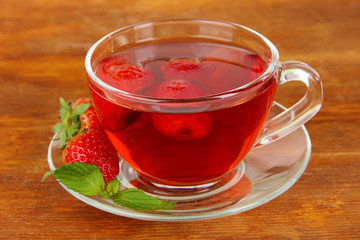 Delicious strawberry tea on table close-up