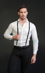 Elegant young man with white shirt and suspenders, serious