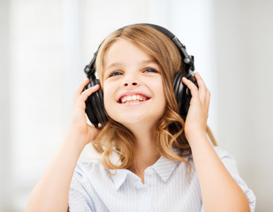 Fototapeta premium smiling little girl with headphones at home