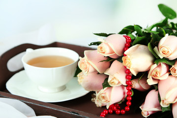 Beautiful bouquet of roses, on wooden tray, on light background