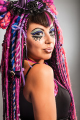 Portrait of a woman with multicolored dreadlocks and stylish mak