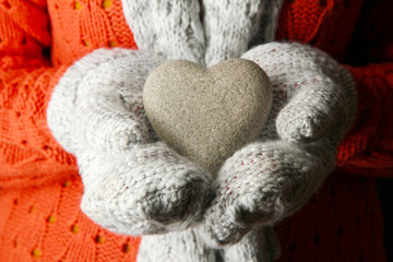Female hands in mittens with heart, close-up