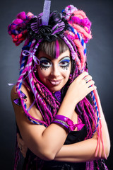 Fototapeta na wymiar Portrait of a woman with multicolored dreadlocks and stylish mak