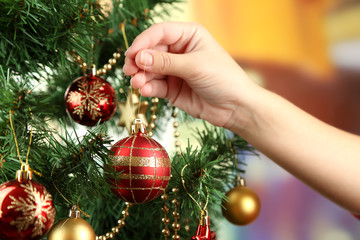 Decorating Christmas tree on bright background