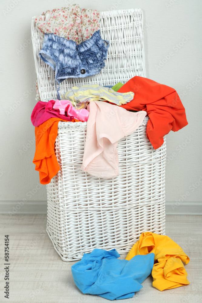 Wall mural Full laundry basket  on wooden floor on gray background