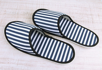 Striped slippers on wooden background