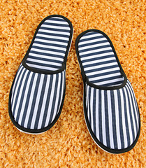 Striped slippers on carpet background