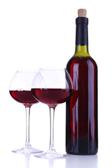Wineglasses with red wine, grape and bottle isolated on white