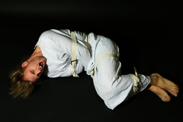 Mentally ill man in strait-jacket on black background