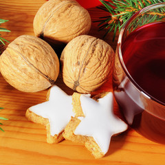 Walnüsse und Zimtsterne mit Teetasse und Tannenzweig