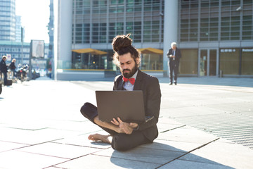 Stylish elegant dreadlocks businessman using notebook