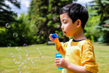 Cute Boy Blowing Soap Bubbles
