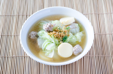 Tofu soup with vegetables and pork on bamboo mat