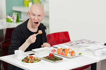 Man eats sushi.