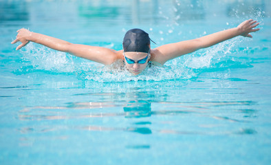 Young girl swimming butterfly stroke style