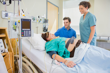 Happy Man And Nurse Looking At Pregnant Woman