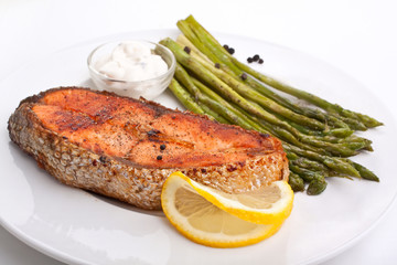 salmon served with vegetables salad, asparagus, lemon and sauce
