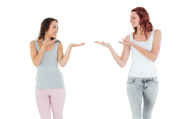 Two happy young female friends holding out their hands