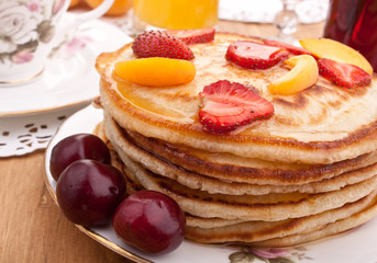 stack of pancakes with syrup and fruit
