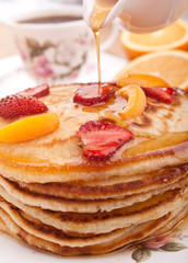 stack of pancakes with syrup and fruit
