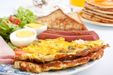 omelette with ham, bacon and vegetables close up