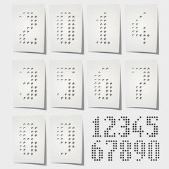 Dotted numbers punched on white paper