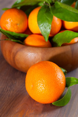 Tangerines in a bowl on wooden background