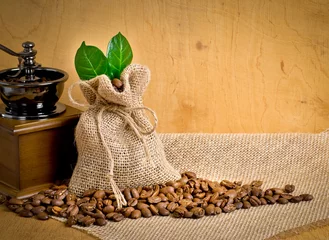Foto op Canvas Coffee grains on sackcloth with bag, leaves and coffee mill © julia_arda