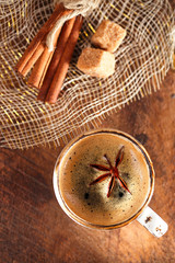 A cup of spiced coffee with anis star and cinamon sticks and sug