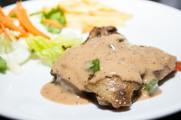 Beef steak with black pepper sauce on a white plate