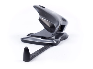 Black puncher used for punching holes in paper over white