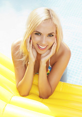 Young happy woman relaxing in a swimming pool