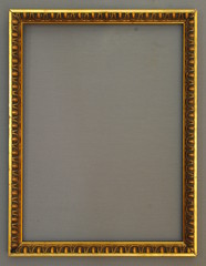 Fototapeta premium Verzierter goldener Bilderrahmen vor grauem Hintergrund