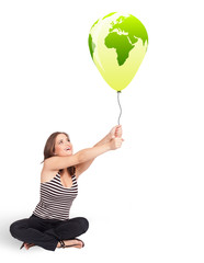 Happy lady holding a green globe balloon