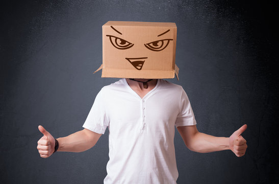 Young man gesturing with a cardboard box on his head with evil f