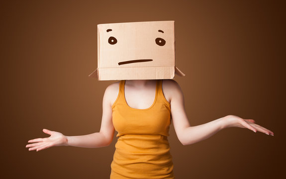 Young girl gesturing with a cardboard box on her head with strai