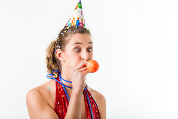 Woman celebrating birthday blowing up balloon