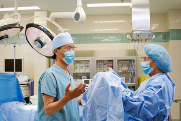 Doctor preparing to don surgical gown