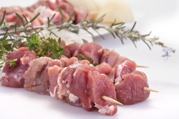 fresh pork skewers with vegetables, onions and rosemary