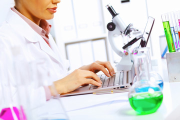 Fototapeta premium Young female scientist working in laboratory