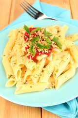 Rigatoni pasta dish with tomato sauce on wooden table close up