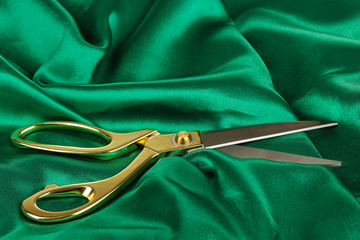 Metal scissors on green fabric