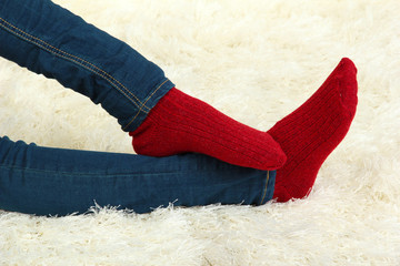 Female legs in colorful socks on  white carpet background