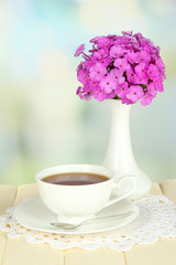 Beautiful bouquet of phlox with cup of tea